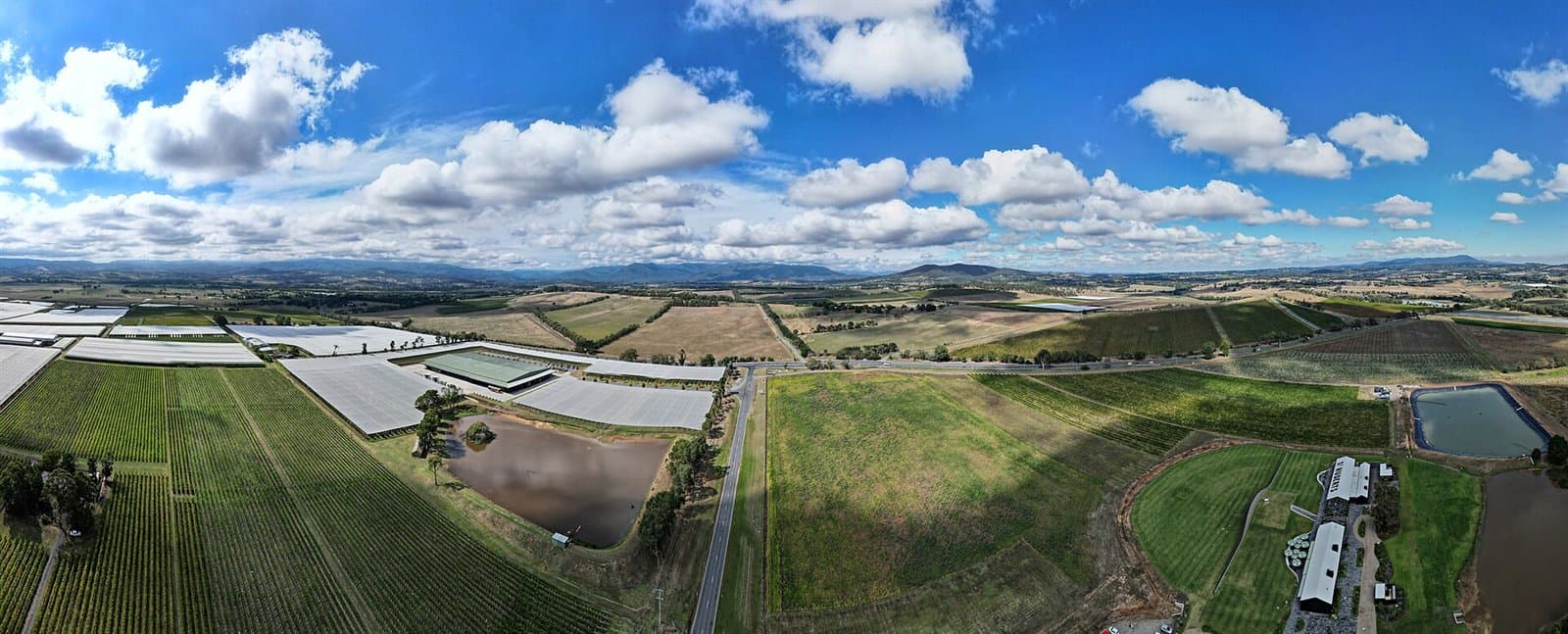 An aerial view across the flat farmland of Coldstream to ranges on the horizon